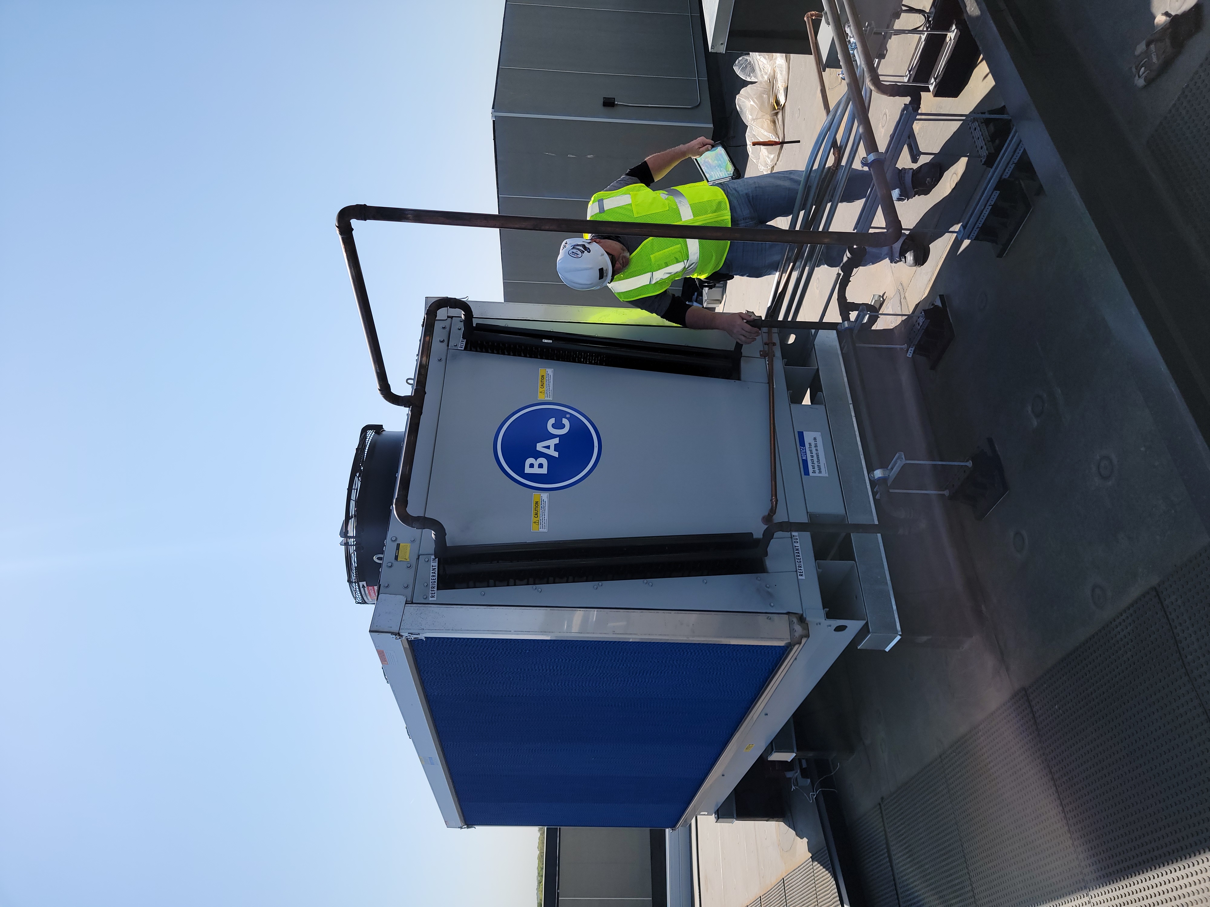 Technician inspecting rooftop mechanical equipment